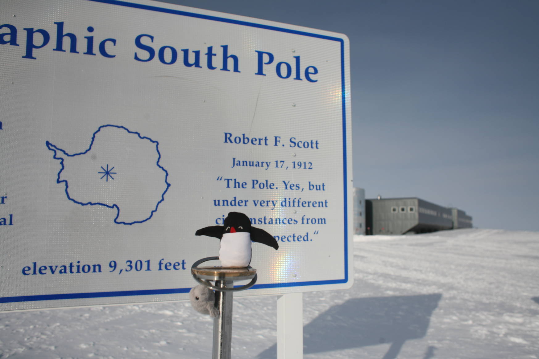 Pete and Debbie climbing the geographical south pole marker, sometime early February.