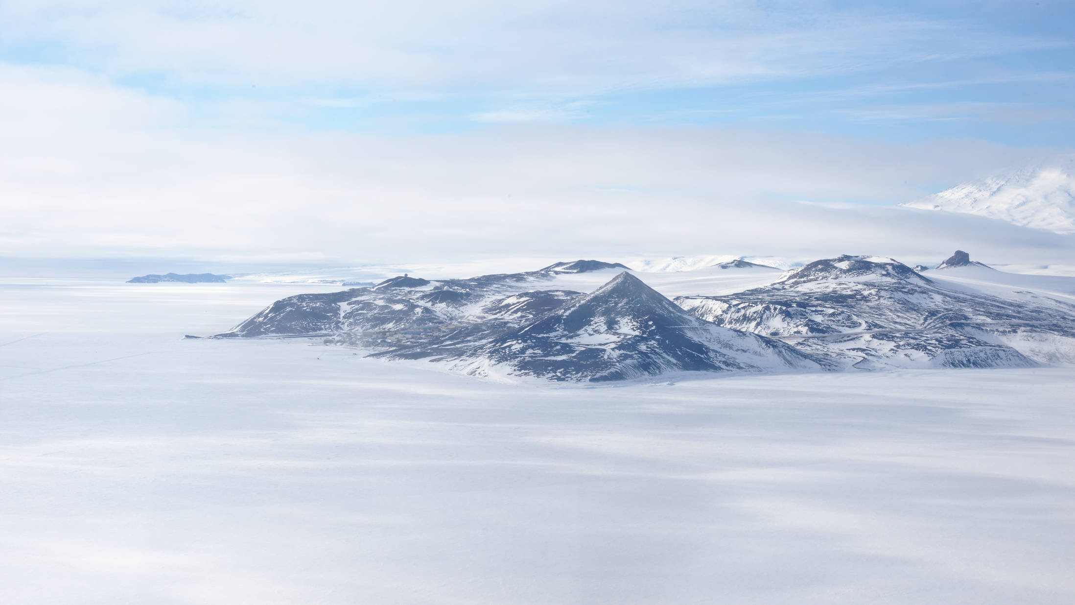 Ross Island - home of McMurdo. Bottom left: Hut point. Middle, front (triangular) mountain: Observation Hill. Between those two: McMurdo. On the right: Castle Rock